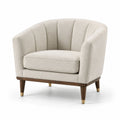 Sillón de tela bouclé beige con patas de madera y detalles metálicos
